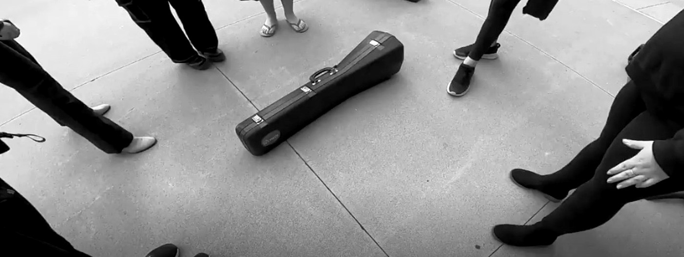 Instrument case set down on the sidewalk between performances